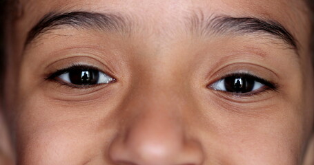 Little girl closing eyes in meditation. Child opening eye smiling, macro close-up
