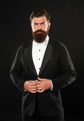 brutal gentleman in tuxedo on black background, formalwear