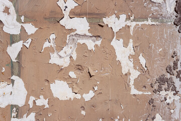 Damaged wall with holes texture background. Creative backdrop. Old, abandoned building interior fragment. Weathered and cracked bricks with concrete, peeled off paint and moss. Close up, copy space