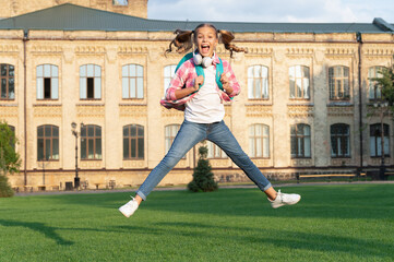 Fototapeta premium Happy active teen girl jumping in school yard outdoors, September 1.