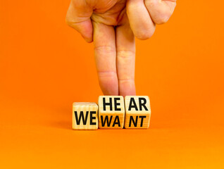 We hear and want symbol. Concept words We hear we want on wooden cubes. Businessman hand. Beautiful orange table orange background. Business and we hear and want concept. Copy space.