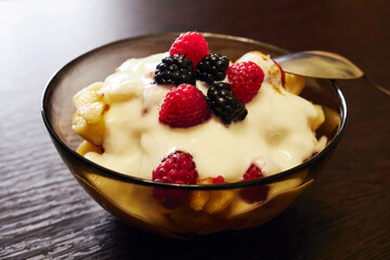 Fresh delicious fruit salad with yogurt on the table close up