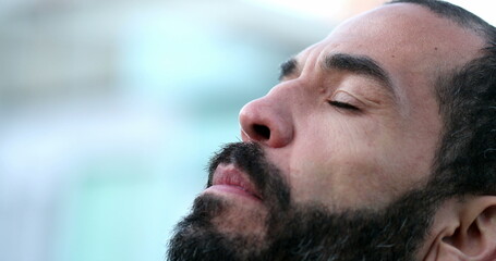 Obraz premium Hispanic man closing eyes in meditation. 40 year old person eyes closed being mindful