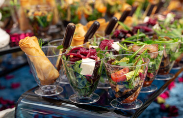 salads and snacks in plastic cups on the buffet