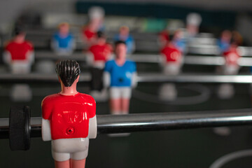 Figures of football players in the board game. Team work. Table football. One against all. Football team. Players on the football field. A popular sport. Running with the ball. Outstanding player.