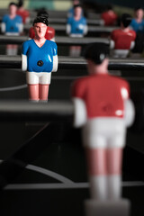 Figures of football players in the board game. Team work. Table football. One against all. Football team. Players on the football field. A popular sport. Running with the ball. Outstanding player.
