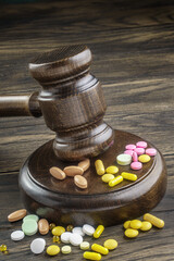 Wooden gavel with drugs on table, closeup. Forensic medicine, pharmaceutical problems in medical practice, expired drugs, fake market. - 517978794