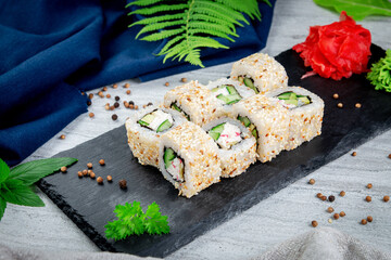 Sushi California rolls with sesame and avocado, crab sauce and cucumber. Traditional Japanese cuisine