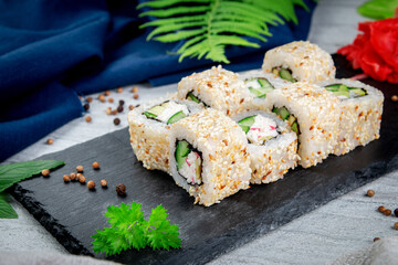 Sushi California rolls with sesame and avocado, crab sauce and cucumber. Traditional Japanese cuisine