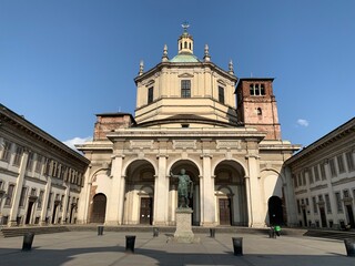 Front facade, exterior of Basilica San Lorenzo Maggiore. Main entrance to the church. Statue, monument in front. It is the oldest church in Milan and famous sightseeing place. Milan, Lombardy, Italy