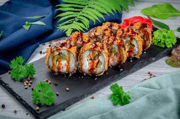 Fried tempura sushi rolls with shrimp, cream cheese, gherkin in batter. Traditional Japanese Cuisine