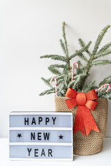 Happy New Year on vintage lightbox with New Years Eve decoration, concept image. Nobilis in a basket of candies.