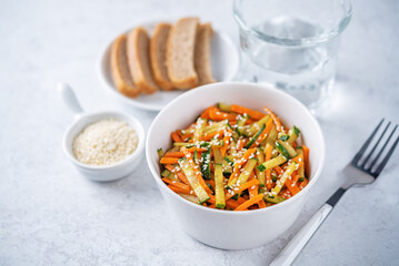 Asian cucumber carrot salad with sesame seeds in a bowl