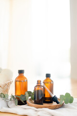 Essential oils in glass dark bottle. Skin and body care treatment concept. Eucalyptus branch.