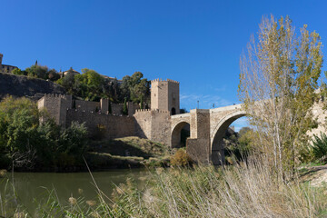 Fototapeta na wymiar Natural landscape of the Tajo river as it passes through the medieval town of Toledo, in the photo we can see a bridge that allows you to cross the river. Spain