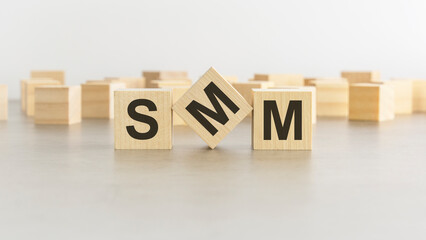 word SMM is made of wooden blocks on white background