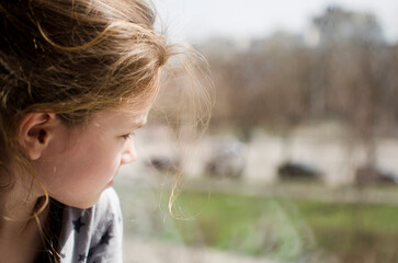The child looks out the window. blurred