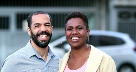 Married interracial couple laughing and smiling. African wife and hispanic mixed race husband. People real life laugh and smile