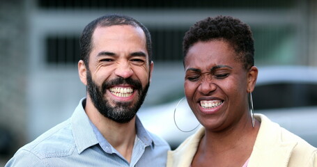 Married interracial couple laughing and smiling. African wife and hispanic mixed race husband. People real life laugh and smile