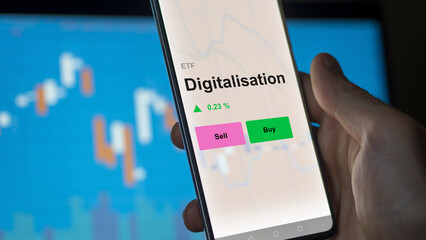 An investor's analizing the digitalisation etf fund on a screen. A phone shows the prices of Digitalisation