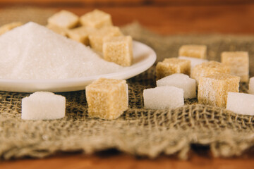 Different sugar on dark table. Sugar is unhealthy nutrition and leads to obesity, diabetes