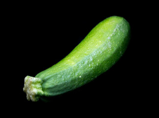 green zucchini lies on a black background