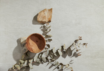 Flatlay minimal natural stone, marble or travertino surface background with stones, a bowl and dry flowers. Template for showcase, presentations, branding, web desing, posts.