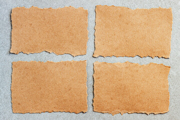 Fototapeta premium Torn brown paper scraps On grey background