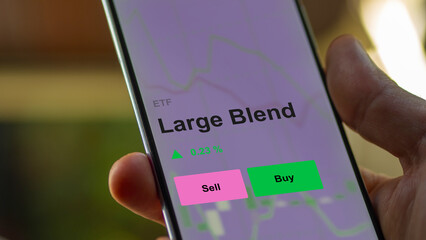 An investor's analizing the large blend etf fund on a screen. A phone shows the prices of mega mix