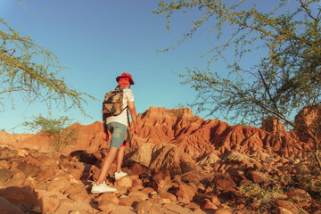 Young traveler backpacking through the desert of the tatacoa, enjoying the landscape in Colombia, red and dry desert