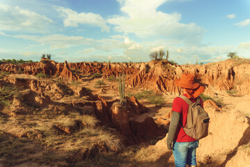Young traveler backpacking through the desert of the tatacoa, enjoying the landscape in Colombia, red and dry desert