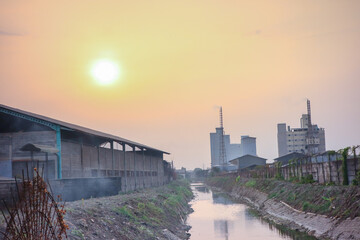 view from outside the factory next to a small clean river at sunset