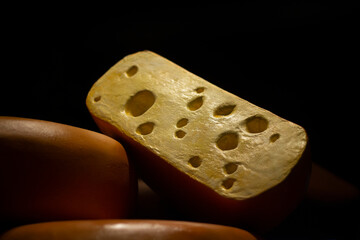 Cheese on dark background. Layout of cheese is made of plastic. Food on counter of store. Dairy products.