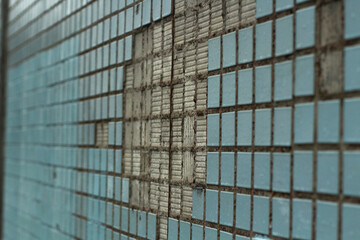 Broken tiles on the wall. The texture of the tiles on the building.