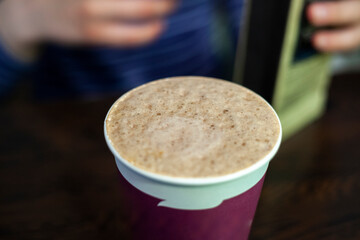 Coffee foam. Coffee in a standard-sized glass. Brown coffee foam on the drink. Sale of coffee in a coffee shop.