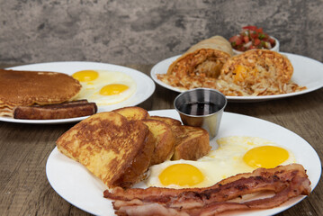 Standard American breakfast choices layed out on the table as a buffet feast of french toast, pancakes, or burrito