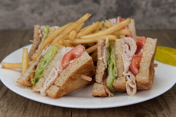 Loaded turkey club sandwich, cut into 4 wedges and covered in french fries will ensure that the belly will be full