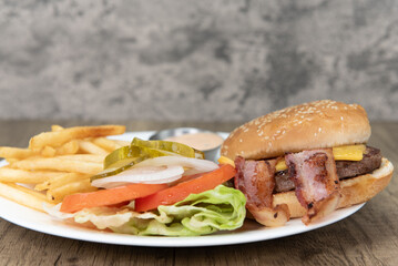 Standard American cheeseburger meal, complete with french fries and pickle, will ensure that the belly will be full