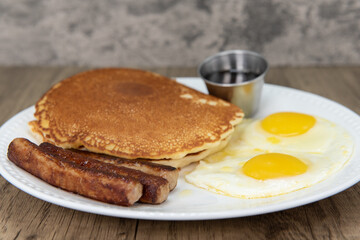 Standard American breakfast consisting of pancakes, fried eggs, and sausage will ensure that the belly will be full