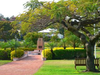 Park with a path leading to a memorial, surrounded by plants and trees