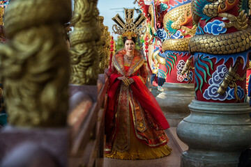 chiness girl in costume. portrait of a woman. person in traditional costume. woman in traditional costume. Beautiful young woman in a bright red dress and a crown of Chinese Queen posing 