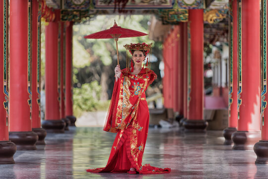 chiness girl in costume. portrait of a woman. person in traditional costume. woman in traditional costume. Beautiful young woman in a bright red dress and a crown of Chinese Queen posing 