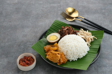 Obraz na płótnie Canvas Gudeg, a typical food from Yogyakarta, Indonesia, made from young jackfruit cooked with coconut milk. Served with spicy stew of cattle skin crackers, brown eggs, shredded chicken and sambal. 