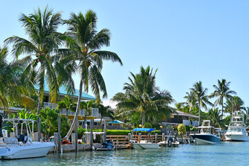 Boats parked along waterfront behind homes in Marathon Key in the Florida Keys - obrazy, fototapety, plakaty