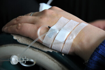 Asian women patient is on drip receiving saline solution