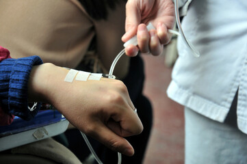Asian women patient is on drip receiving saline solution