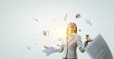 Young pretty businesswoman juggling with business items