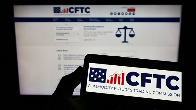 Stuttgart, Germany - 07-13-2022: Person holding smartphone with logo of US Commodity Futures Trading Commission (CFTC) on screen in front of website. Focus on phone display.