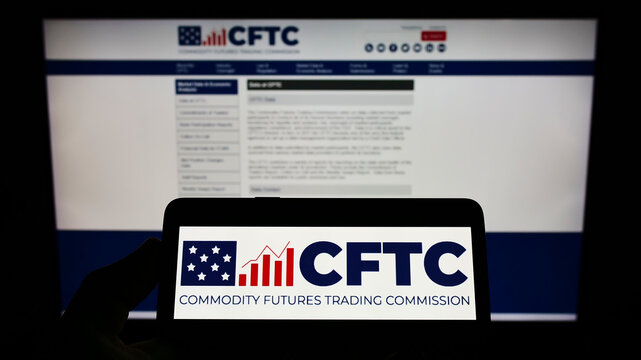 Stuttgart, Germany - 07-13-2022: Person holding cellphone with logo of American Commodity Futures Trading Commission (CFTC) on screen in front of webpage. Focus on phone display.