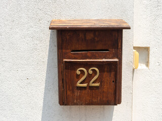 An old wooden mailbox hangs on a white wall. Galle, Sri Lanka